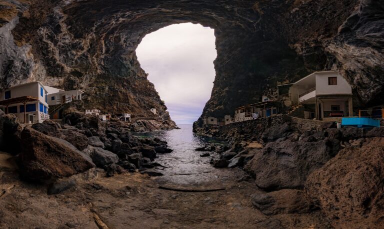 Cueva marina con casitas blancas a ambos lados y vistas al mar desde el interior rocoso de Poris de Candelaria