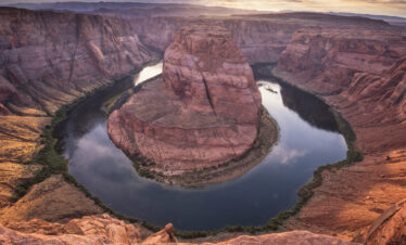 Herradura del Río Colorado con acantilados de arenisca roja al atardecer en el desierto de Arizona
