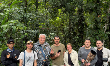 Grupo de siete fotógrafos y guías de expedición en la selva tropical con equipos de fotografía profesional