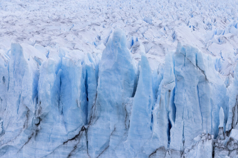 Formaciones de hielo azul y blanco en glacier de Patagonia con grietas y cristales congelados