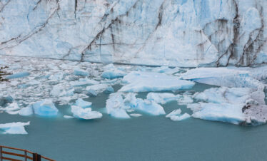Viajero en mirador observa el glaciar Perito Moreno con icebergs flotantes en el lago glaciar de Patagonia