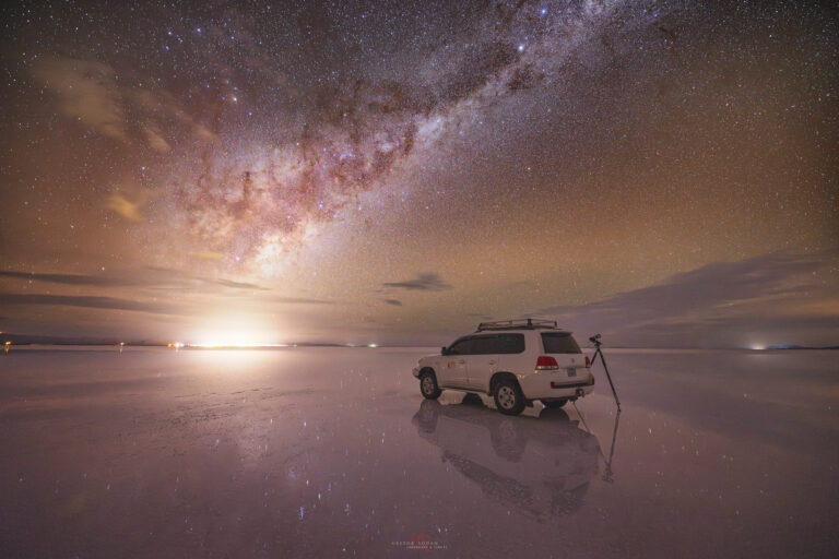 Vehículo 4x4 en el Salar de Uyuni bajo la Vía Láctea al atardecer
