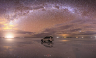 Vehículo 4x4 en el Salar de Uyuni bajo la Vía Láctea y cielo estrellado al atardecer