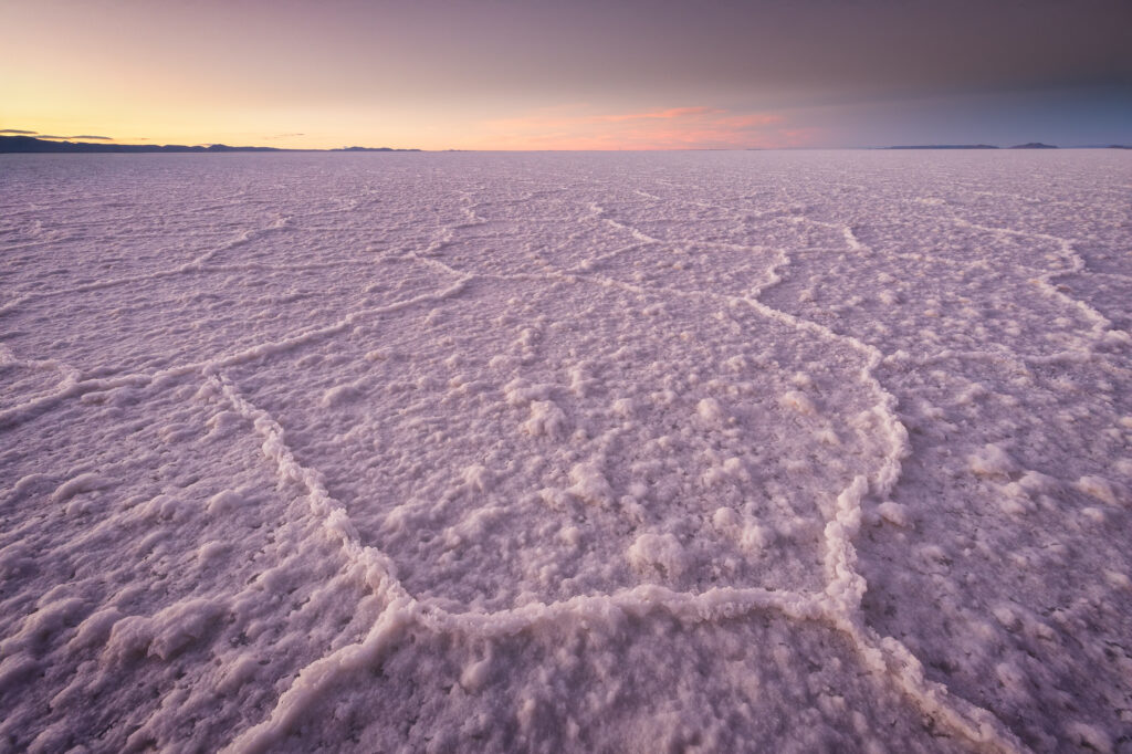 Llanura de sal blanca con patrones hexagonales al atardecer en el Salar de Uyuni, Bolivia