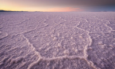 Llanura de sal blanca con patrones hexagonales al atardecer en el Salar de Uyuni, Bolivia