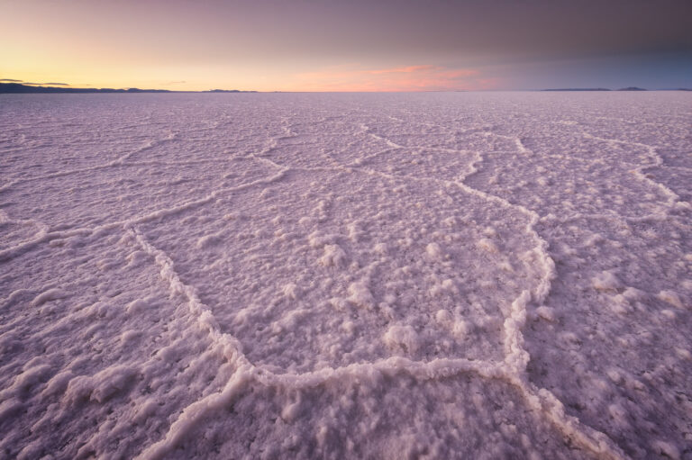 Llanura de sal blanca con patrones hexagonales al atardecer en el Salar de Uyuni, Bolivia