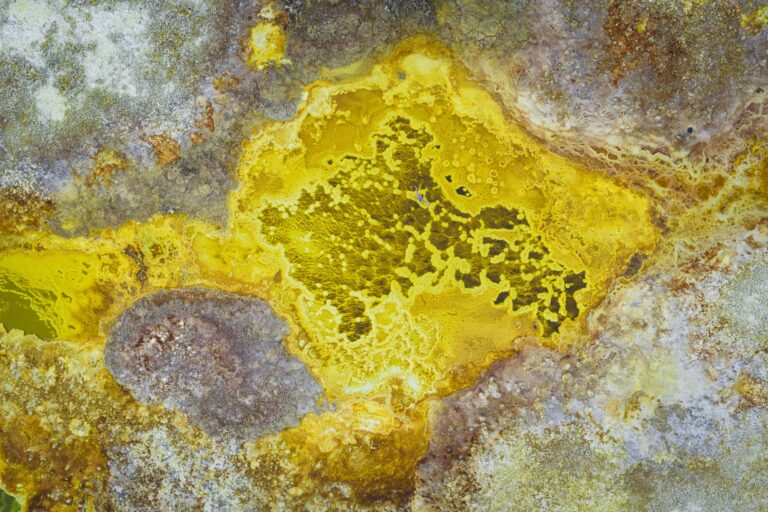 Depósitos minerales amarillos y grises en formaciones geotérmicas con texturas cristalizadas