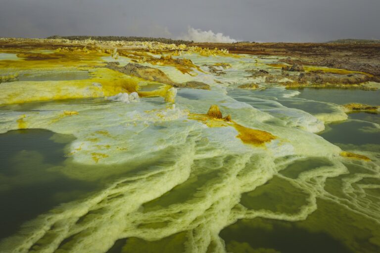 Formaciones geotérmicas de sulfur con depósitos amarillos y aguas termales verdiazules en Etiopía
