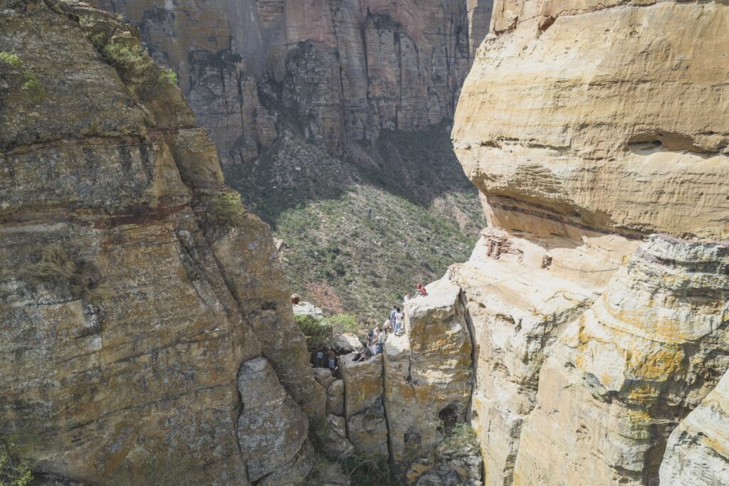 Garganta de roca con sendero entre acantilados de piedra arenisca y senderistas explorando el cañón