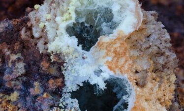 Roca volcánica con cristales minerales blancos y depósitos de azufre amarillo en Etiopía