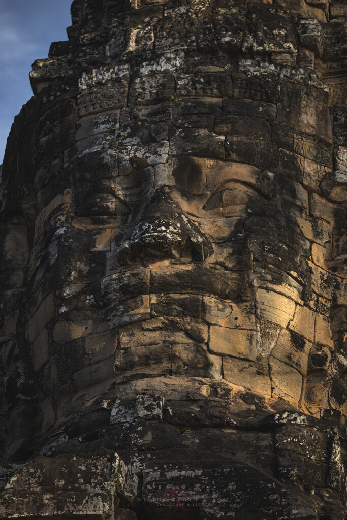 Rostro monumental tallado en piedra arenisca de un templo jemer en Camboya, con detalles erosionados por el tiempo
