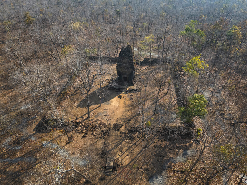 Templo de piedra en ruinas rodeado de bosque quemado y árboles carbonizados en Camboya