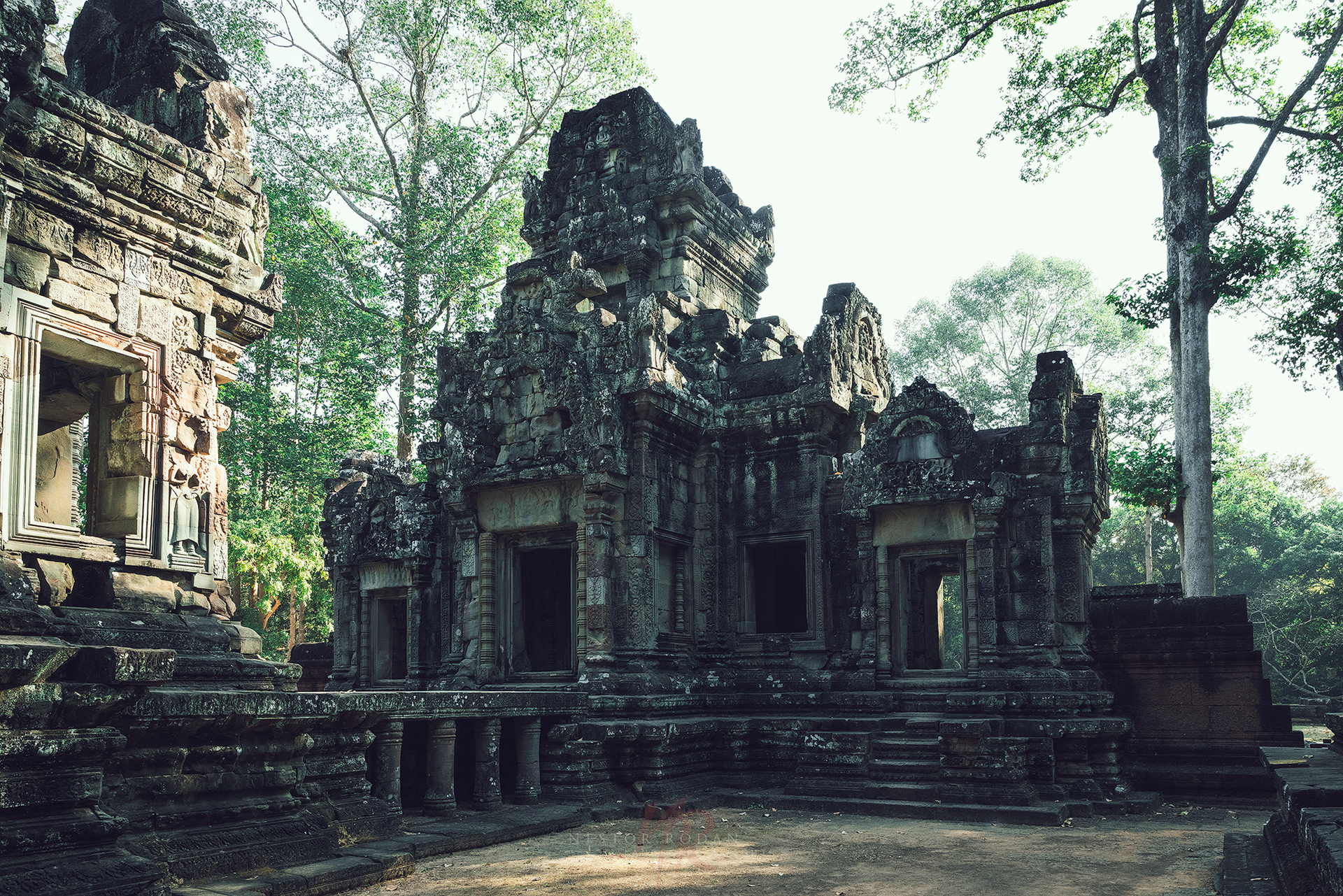 Ruinas de templo de piedra con torres ornamentadas rodeadas de vegetación selvática en Camboya