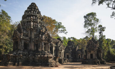 Templo de piedra con torres ornamentadas rodeado de selva tropical y árboles frondosos