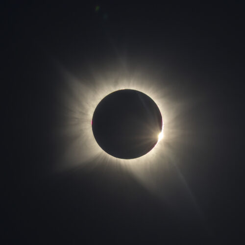Eclipse solar total con corona visible alrededor de la luna negra contra cielo oscuro