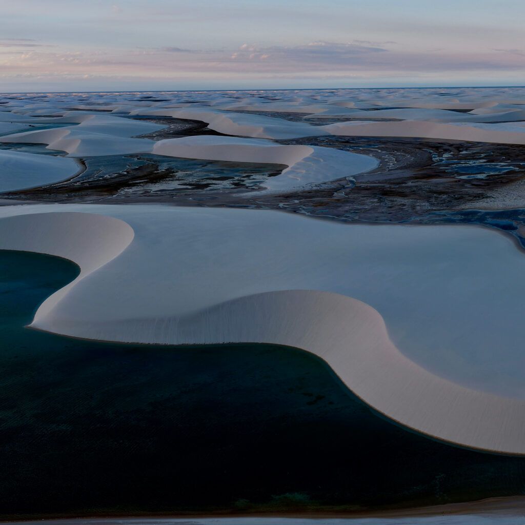 Lagunas de agua dulce entre dunas de arena blanca en Lençóis Maranhenses, Brasil, al atardecer