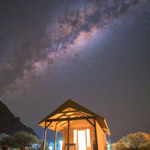 Cabaña iluminada en el desierto de Namibia bajo la Vía Láctea