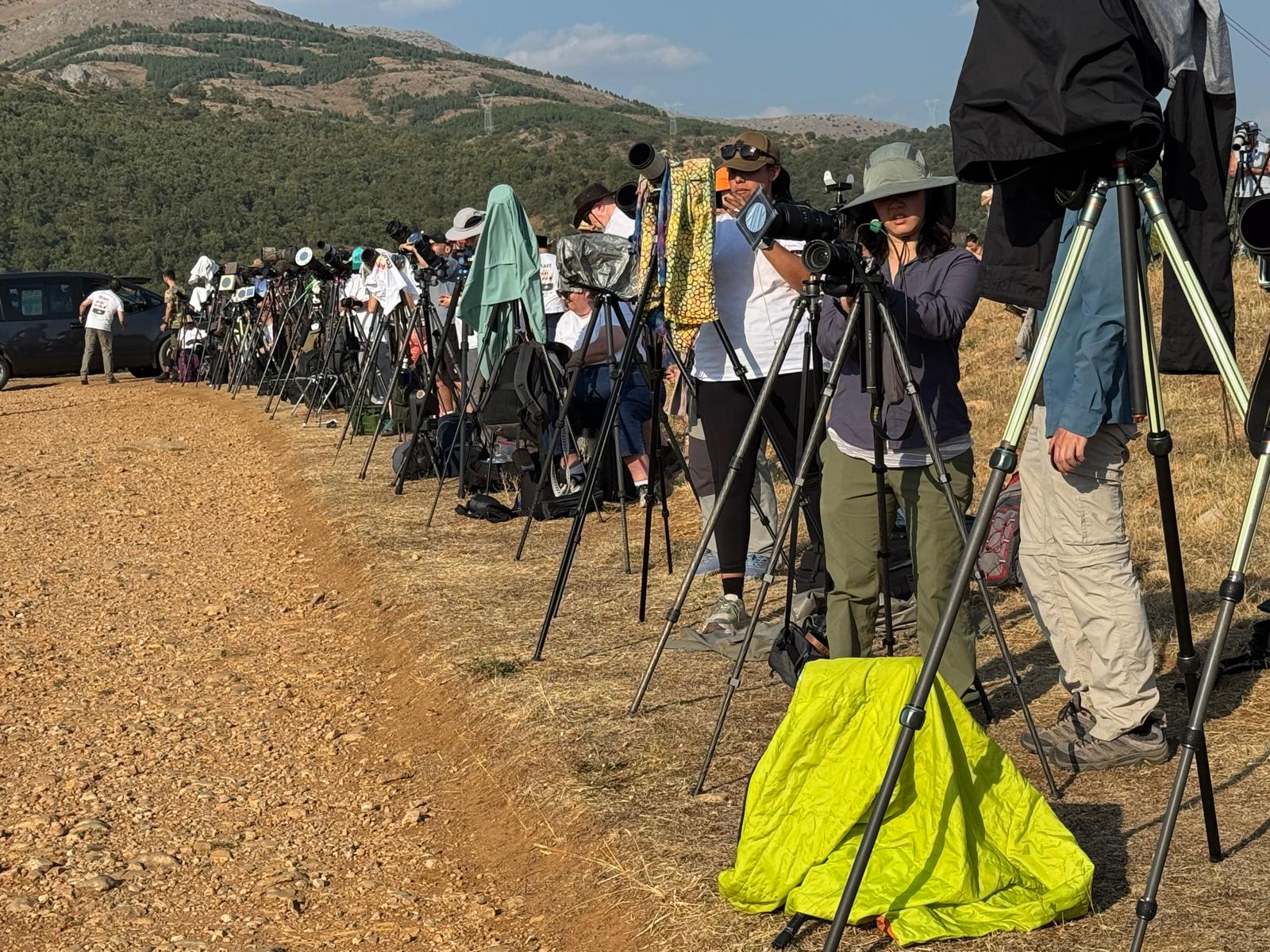 Grupo de observadores astronómicos con telescopios en montaña árida bajo cielo despejado