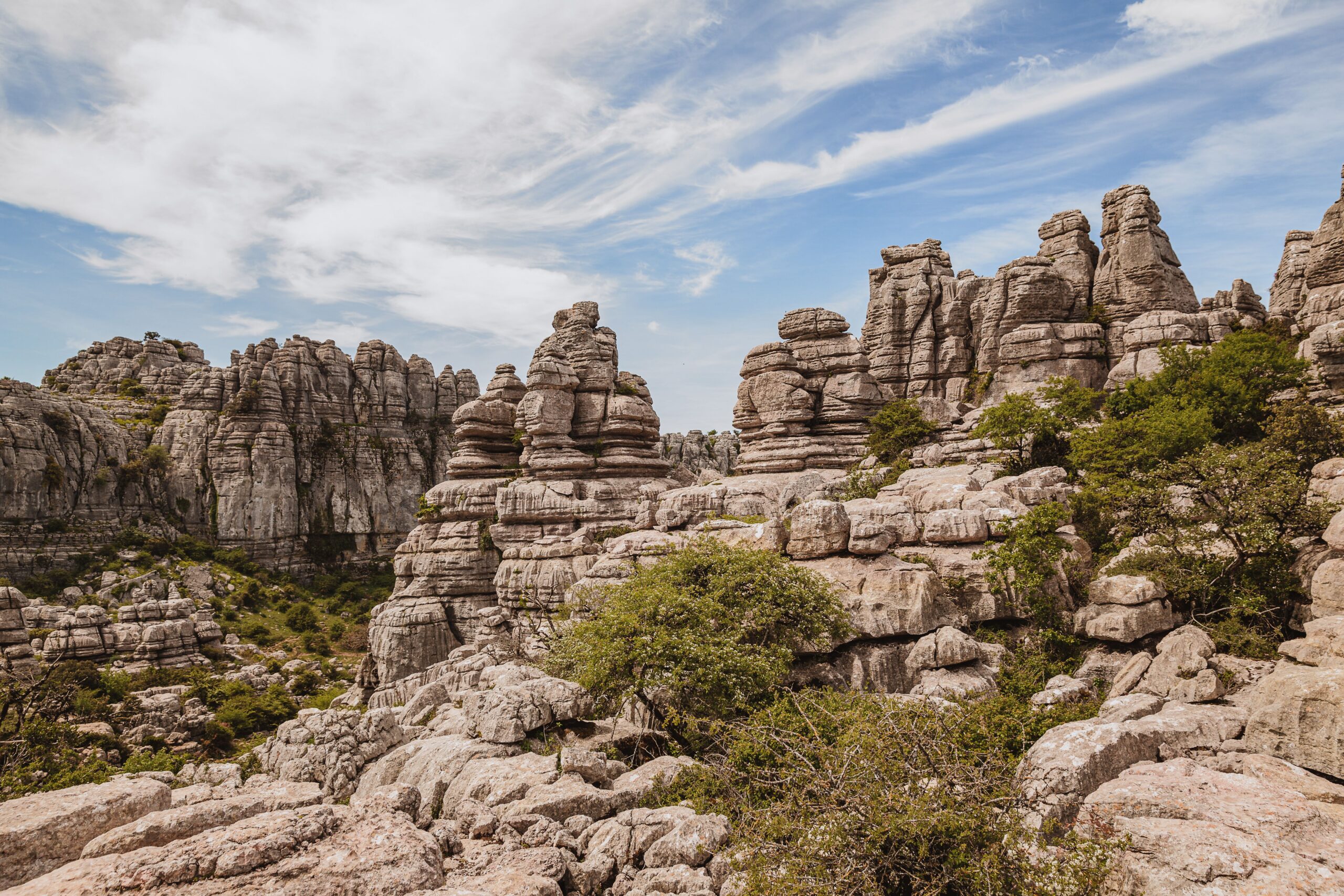 Formaciones rocosas calizas del Torcal de Antequera con vegetación dispersa y cielo azul