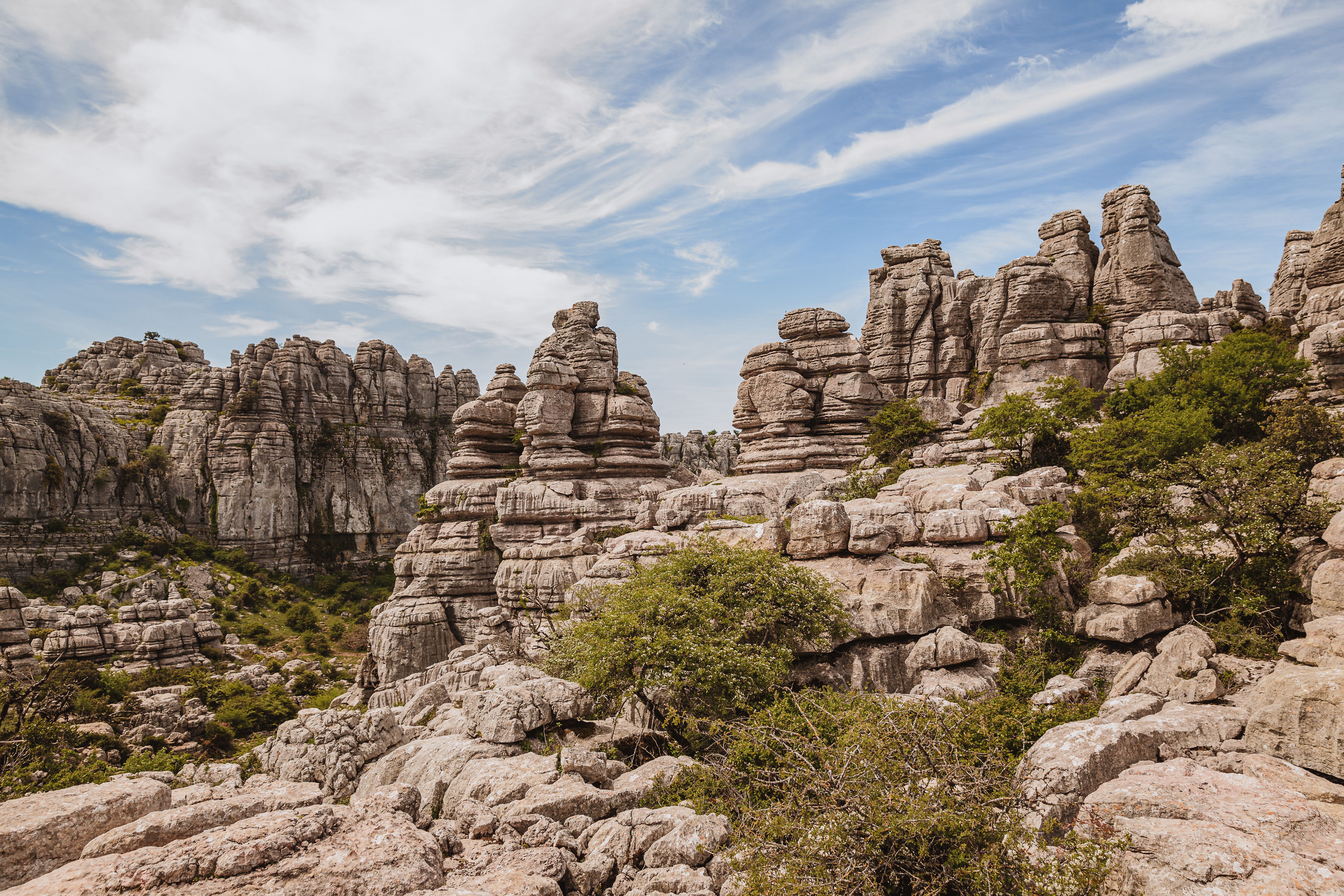 Formaciones rocosas calizas del Torcal de Antequera con vegetación dispersa y cielo azul