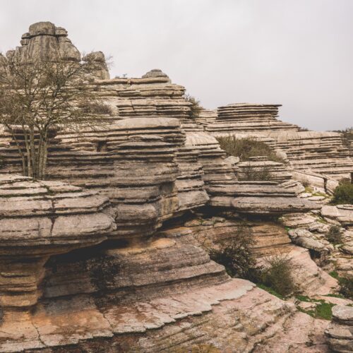 Formaciones rocosas estratificadas del Torcal de Antequera con vegetación dispersa y cielo nublado