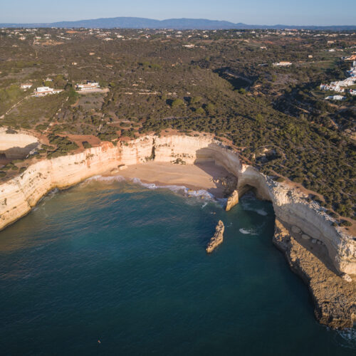 Acantilados de piedra caliza blanca con playa y formaciones rocosas en el Algarve portugués