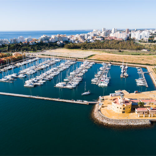 Marina con cientos de veleros amarrados en filas ordenadas frente a la costa del Algarve portugués