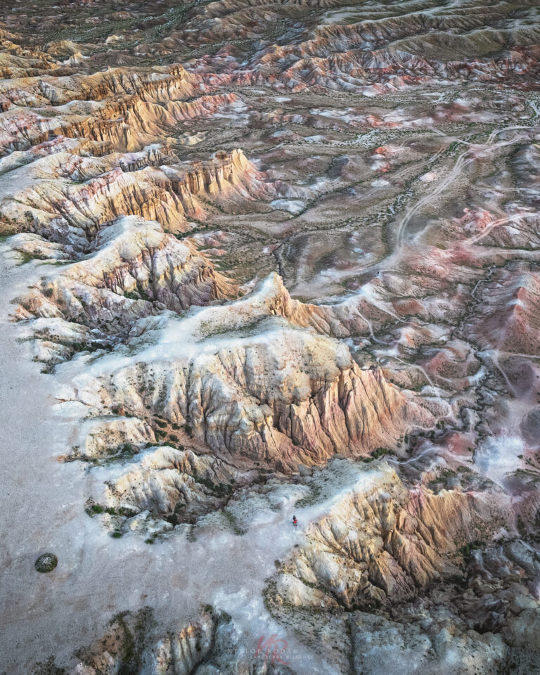 Formaciones geológicas de terrazas minerales en tonos ocres, naranjas y rojos con depósitos de agua termal en Mongolia