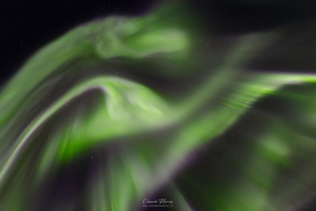 Luces verdes borrosas de aurora boreal contra cielo nocturno estrellado en Abisko