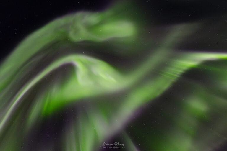 Luces verdes borrosas de aurora boreal contra cielo nocturno estrellado en Abisko