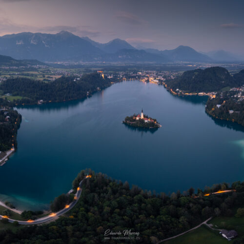 Lago Bled al atardecer con iglesia en isla, bosques y montañas de fondo en Eslovenia