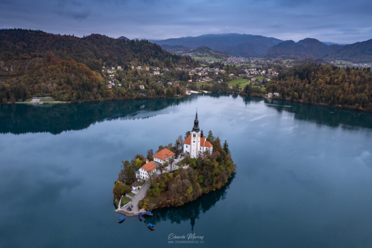 Iglesia de la Asunción en isla del lago Bled rodeada de bosques y montañas en Eslovenia
