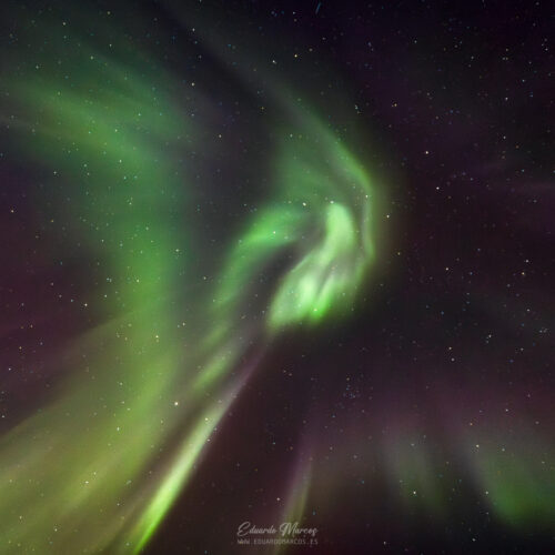 Aurora boreal con cortinas verdes brillantes ondulando en el cielo nocturno estrellado de Abisko