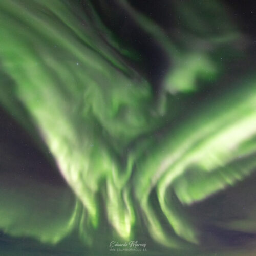 Aurora boreal verde intenso ondulante en el cielo nocturno estrellado de Abisko